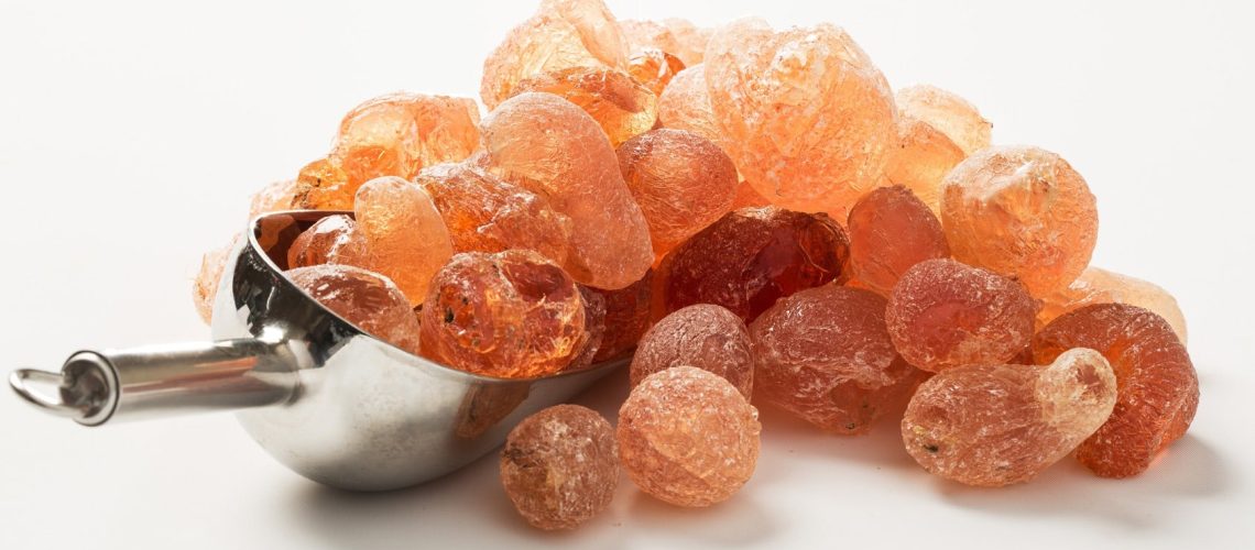 Gomme arabique en morceaux ambrés et en poudre blanche dans un bol